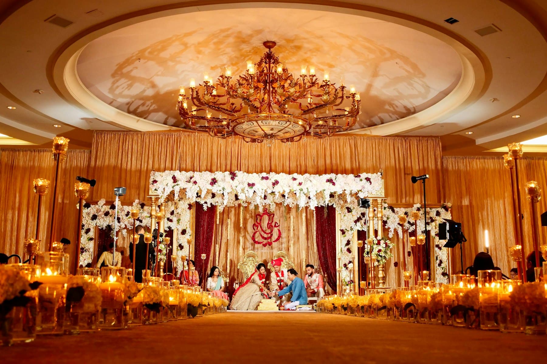 Gold-draped Indian wedding mandap lit by candles