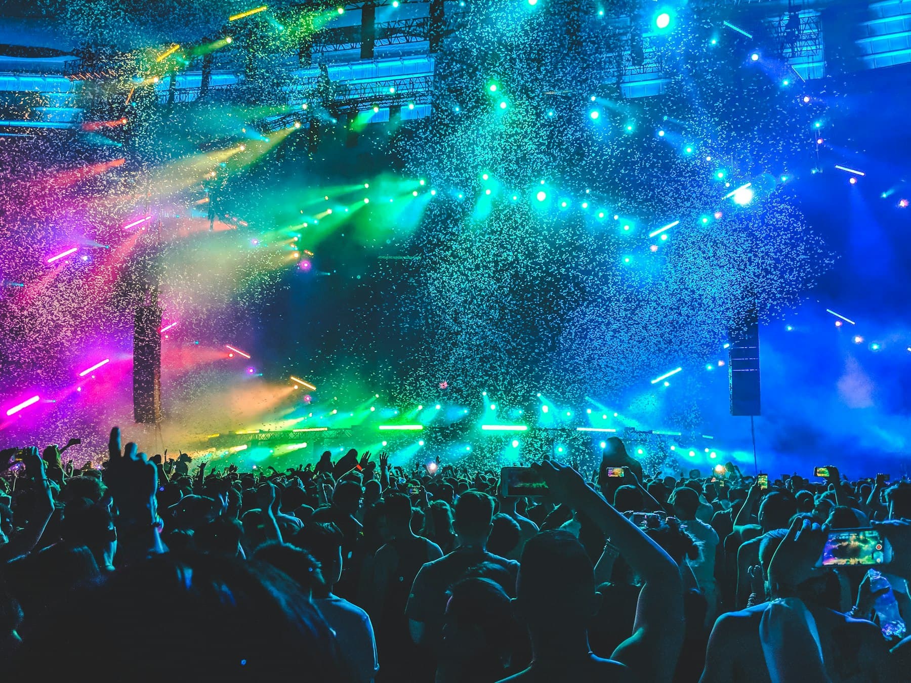Concert lighting and confetti over a crowd
